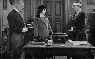 Alathea (Harriet Hammond) disguised with colored glasses and plain clothes arrives to take up her duties as secretary to Sir Nicholas (Lew Cody). (A scene from Elinor Glyn's production "Man and Maid" for Metro-Goldwyn-Mayer)