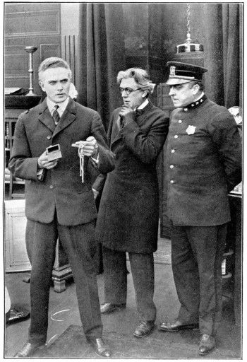 Three men (one a police officer) look perplexed.