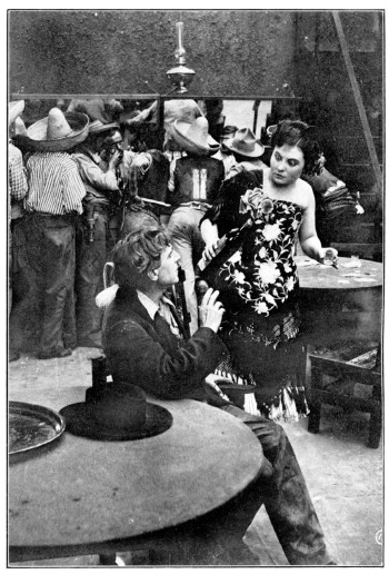 A woman talks with a man in a saloon.