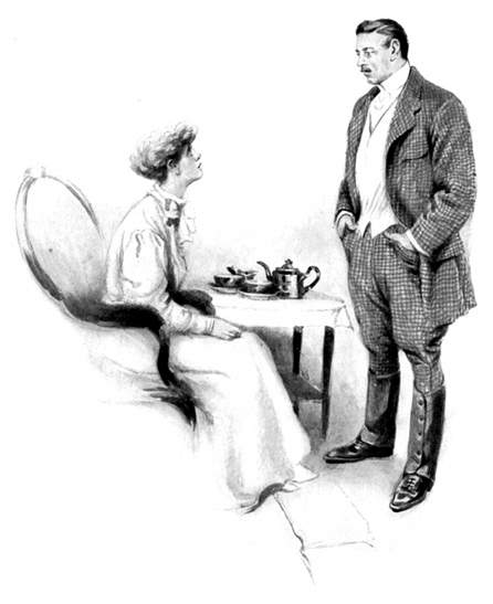 A seated woman talks to a standing man.