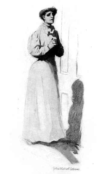 A woman stands outside of a closed door.