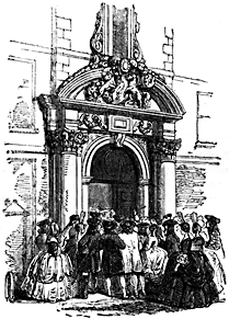 A crowd stands around an archway.