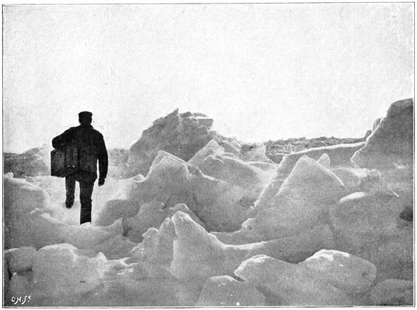 Man walking on ice, carry large bag.