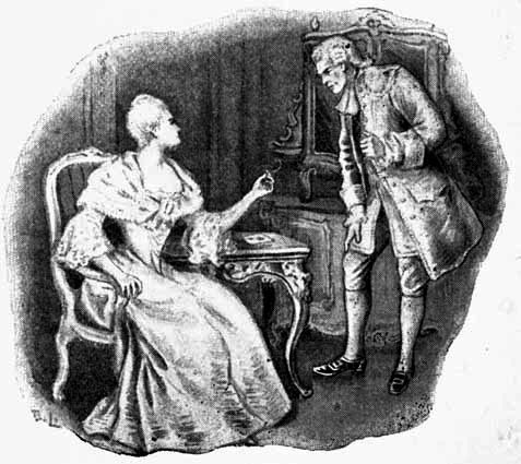 A woman, sitting in a chair, speaking to a man standing by her.