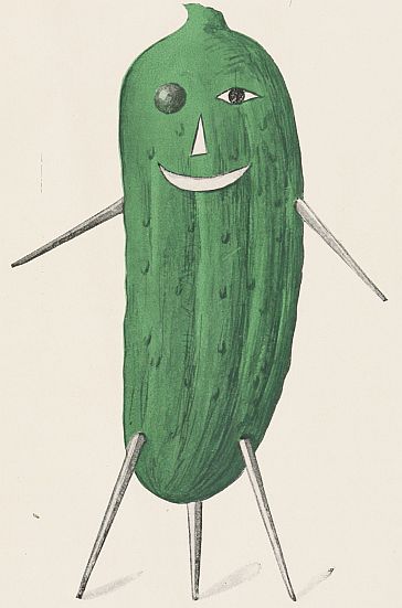 Green cucumber with a black bead eye and one drawn on, a nose and mouth and toothpick arms and three legs